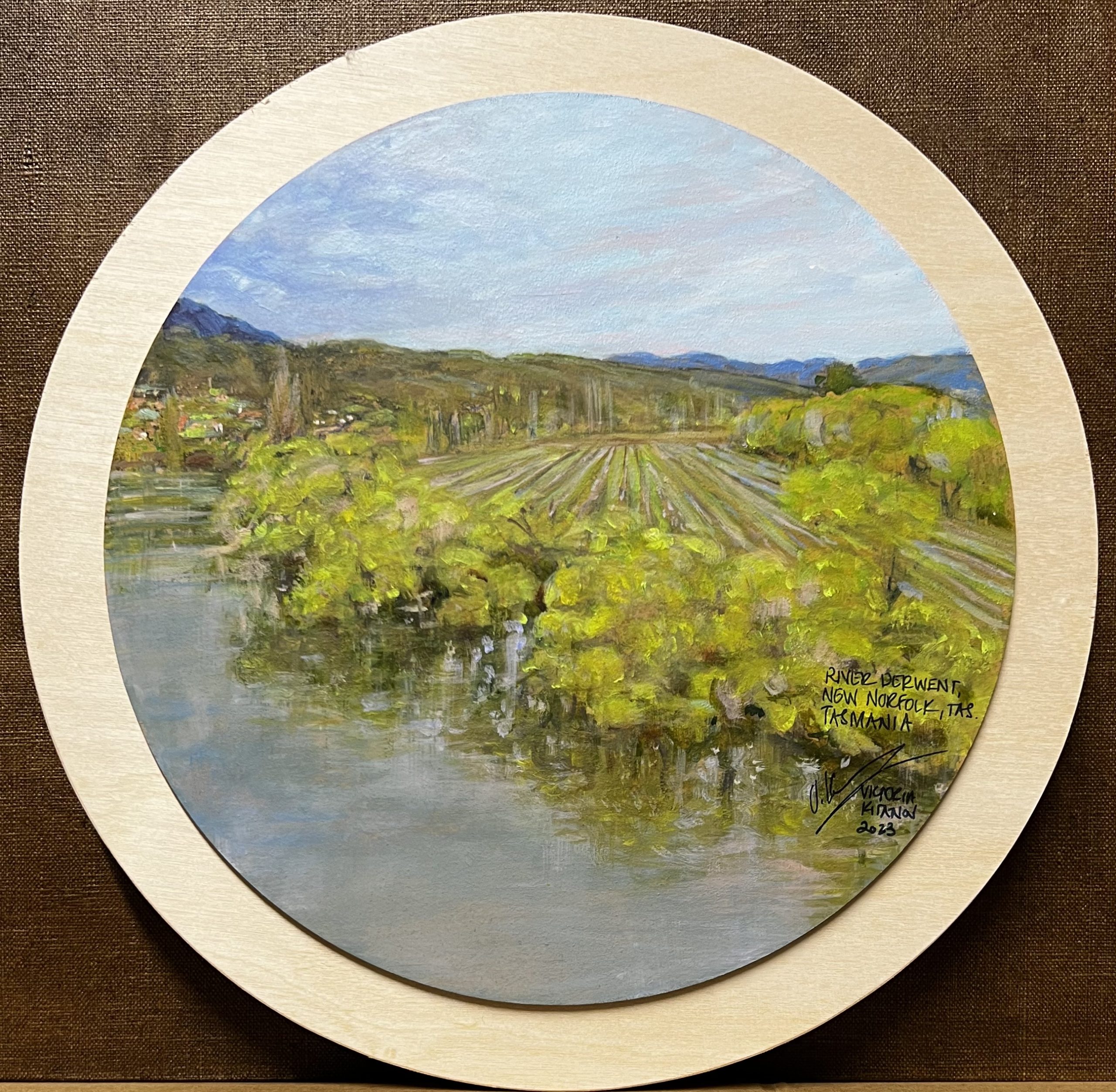 Across the fields above the River Derwent, New Norfolk, Tasmania ©2023 (Acrylic on MDF, mounted on timber disc; 30 cm.) $350.00